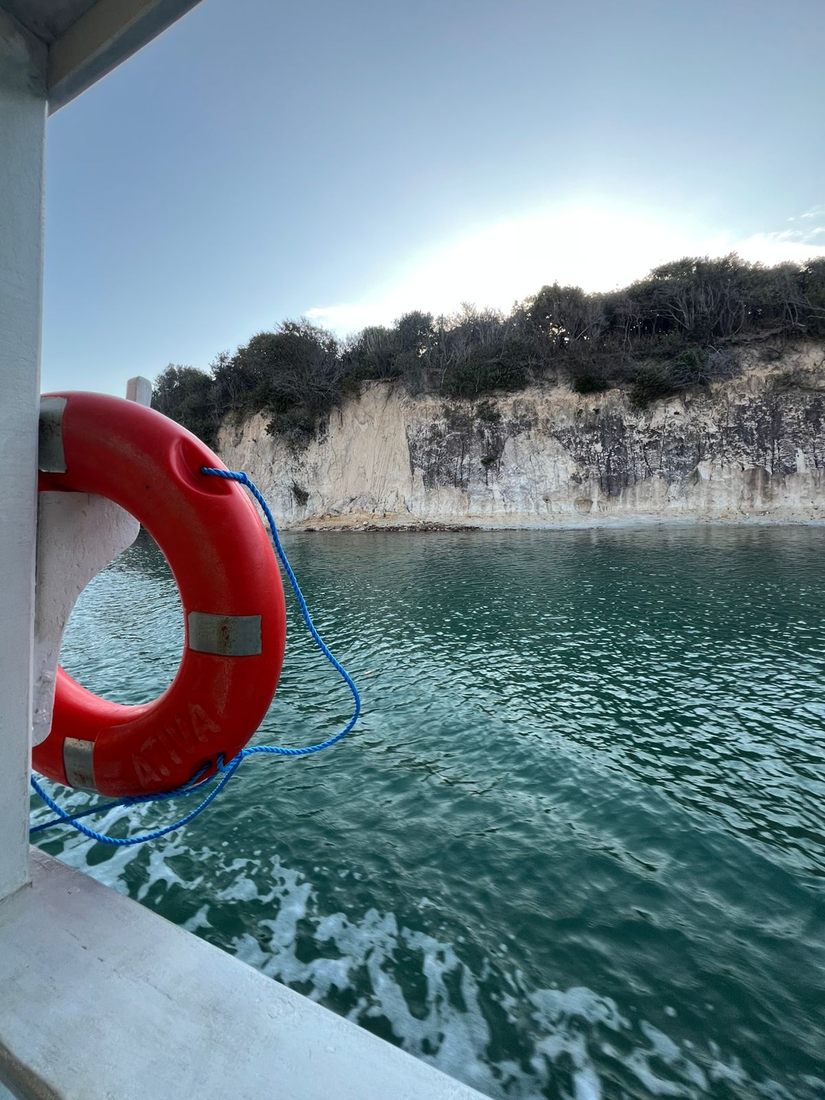 Travessia de balsa sobre o rio, com a paisagem de dunas ao fundo.